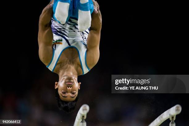 Ashish Kumar of India competes on the parallel bars during the men's team final and individual qualification in the artistic gymnastics event during...