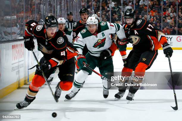 Zach Parise of the Minnesota Wild battles for position against Ryan Kesler of the Anaheim Ducks as Hampus Lindholm of the Anaheim Ducks gains control...