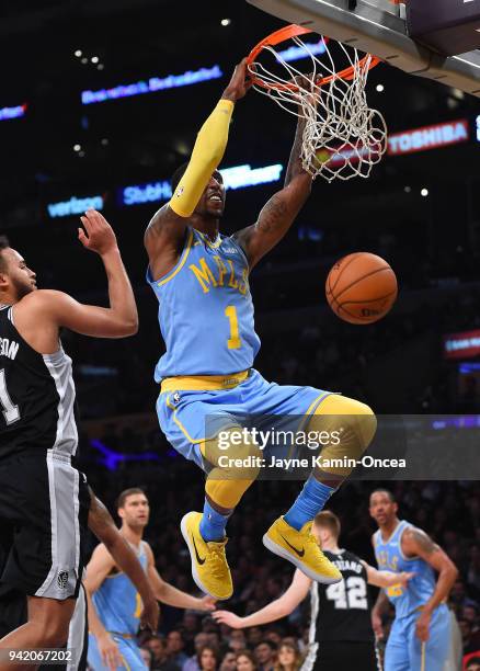 Kentavious Caldwell-Pope of the Los Angeles Lakers dunks past Kyle Anderson of the San Antonio Spurs in the first half of the game at Staples Center...