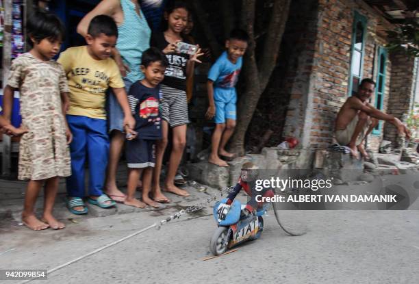 Ucil, a monkey trained to perform various tricks popularly known as "topeng monyet" or masked monkey, entertains residents in a neighbourhood in...