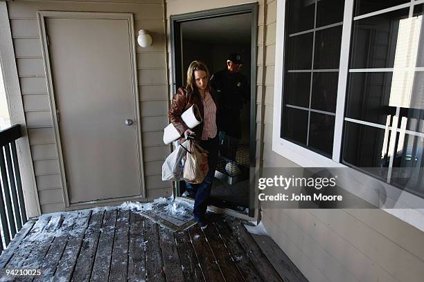 Rachael Kozhevnikova carries out important personal items after being evicted from her apartment on December 9, 2009 in Colorado Springs, Colorado....