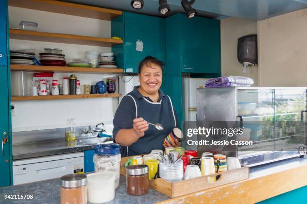 a woman makes tea in a factory cafeteria - new zealand small business stock pictures, royalty-free photos & images