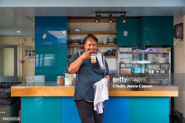 A woman drinks tea in a factory cafeteria