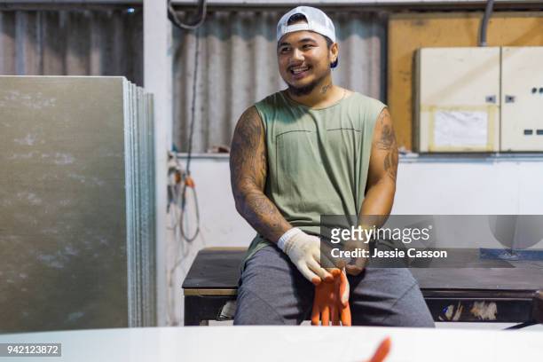 portrait of a pacific island manual worker smiling in a warehouse - tradesman stock pictures, royalty-free photos & images
