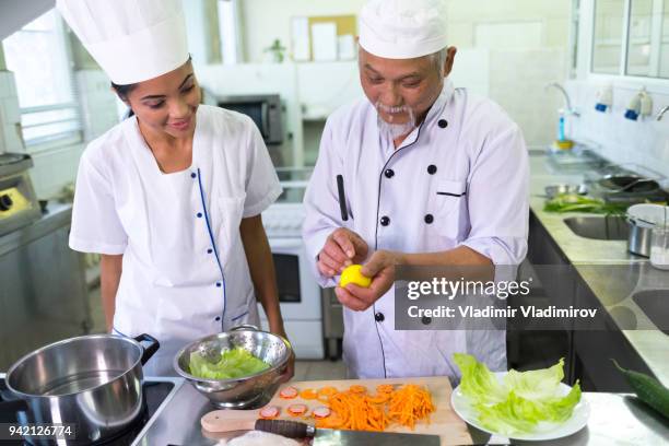 chef and assistant preparing salad in asian restaurant - chef salad stock pictures, royalty-free photos & images