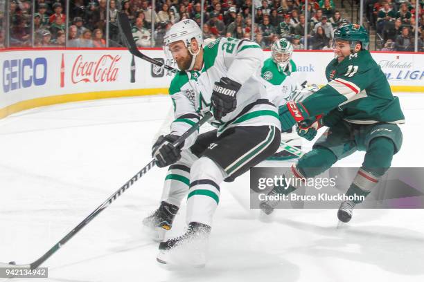 Greg Pateryn of the Dallas Stars skates with the puck while Zach Parise of the Minnesota Wild defends during the game at the Xcel Energy Center on...