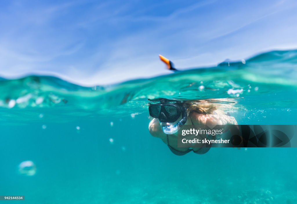 Mujer de explorar el mar mientras que snorkeling en día de verano.