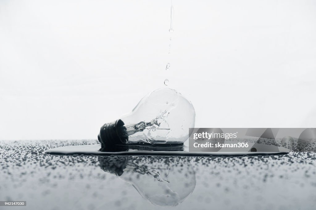 Creative light bulb and splash water on background