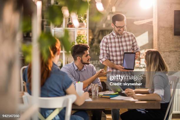 start up team planning monthly activities on touchpad during a meeting. - calendar 2017 imagens e fotografias de stock