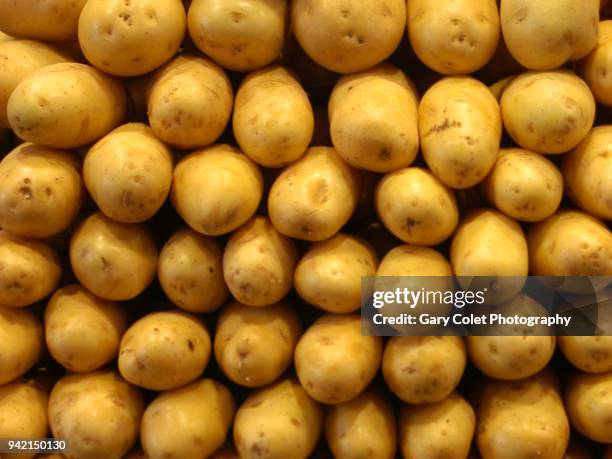 fresh potatoes piled high on market stall - gary colet stock pictures, royalty-free photos & images