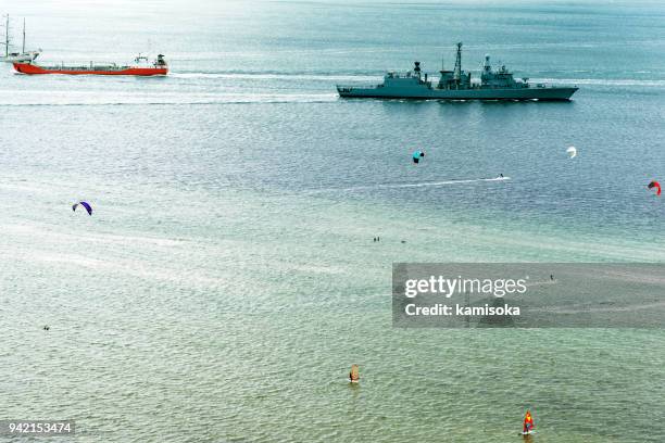 wind surfers and military boat - microwave tower stock pictures, royalty-free photos & images