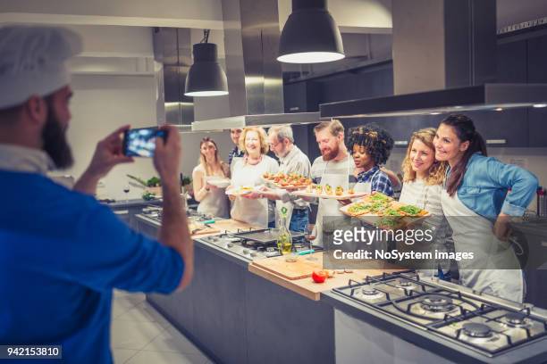 chef is photographing attendees of cooking class - art and craft product stock pictures, royalty-free photos & images