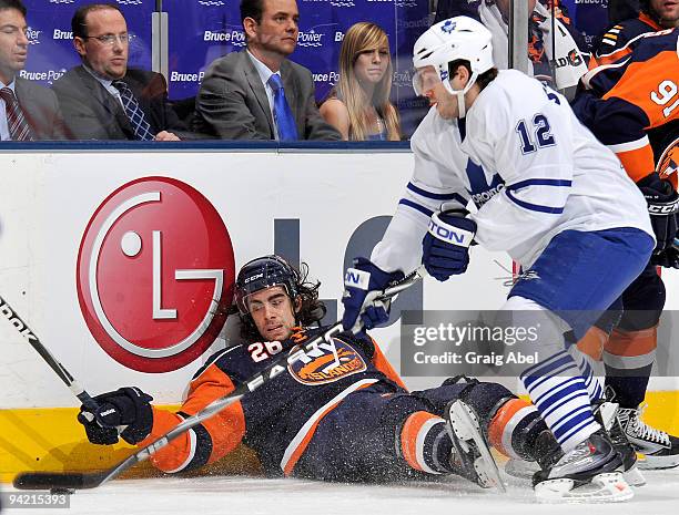 Lee Stempniak of the Toronto Maple Leafs skates the puck away from a fallen Matt Moulson of the New York Islanders during game action December 9,...