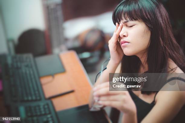 mujer joven con dolor de ojos después de trabajar en equipo. - bloodshot fotografías e imágenes de stock