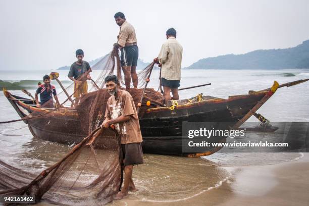 fishermen detangling their net - palolem beach stock pictures, royalty-free photos & images