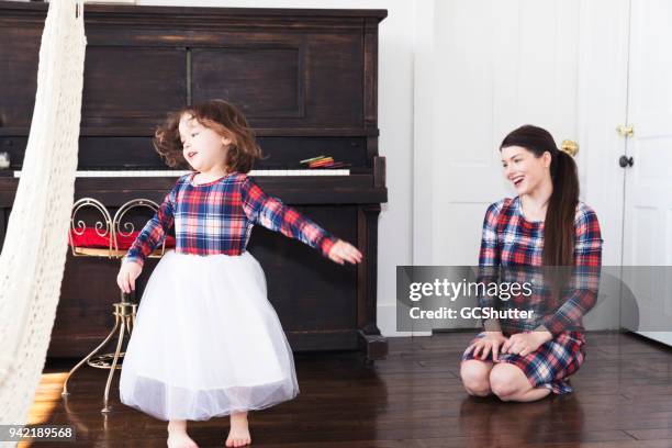 daughter singing and dancing for her happy mother - girls in plaid skirts stock pictures, royalty-free photos & images