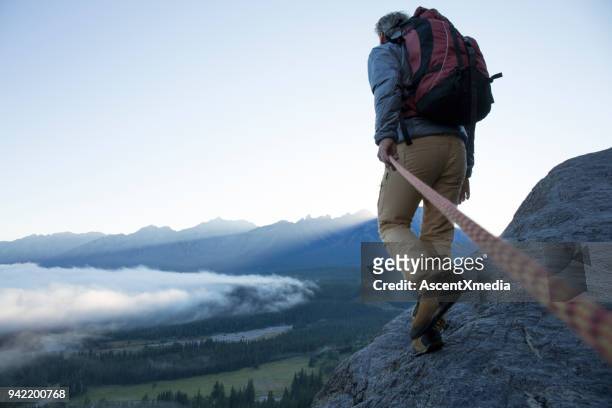 male mountaineer traverses mountain ridge at sunrise canadian rockies - dedication stock pictures, royalty-free photos & images