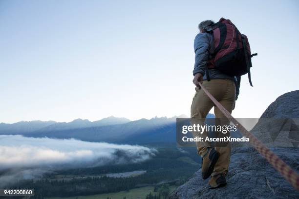 männliche bergsteiger traversen bergrücken bei sonnenaufgang kanadischen rockies - safety stock-fotos und bilder