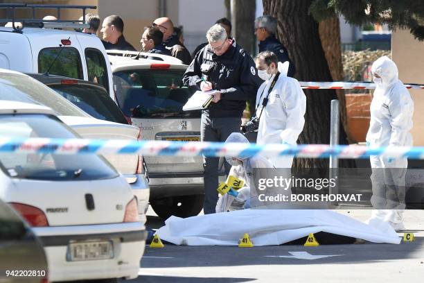 French Police forensics collect evidences near the body of one of two men shot dead earlier on April 5, 2018 in Marseille's 10th arrondissement in...
