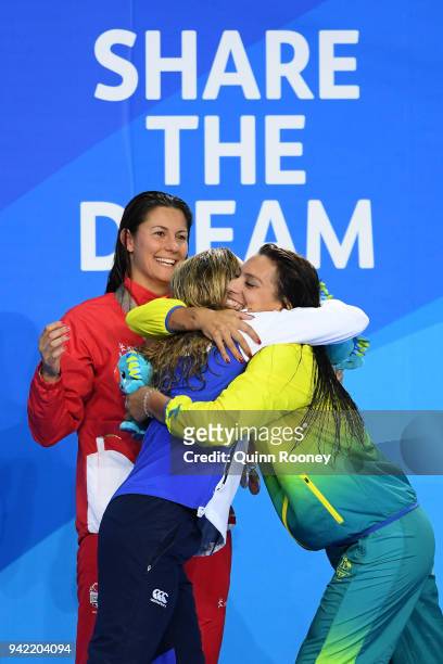 Silver medalist Hannah Miley of Scotland embraces bronze medalist Blair Evans of Australia as gold medalist Aimee Willmott looks on during the medal...