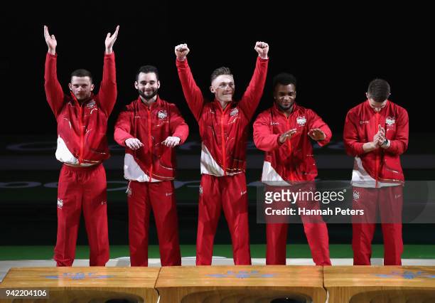 Gold medalists Max Whitlock, Nile Wilson, Courtney Tulloch, James Hall and Dominick Cunningham of England stand on the podium during the medal...