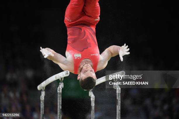 Britain's Dominick Cunningham competes on the parallel bars during the men's team final in the artistic gymnastics event during the 2018 Gold Coast...