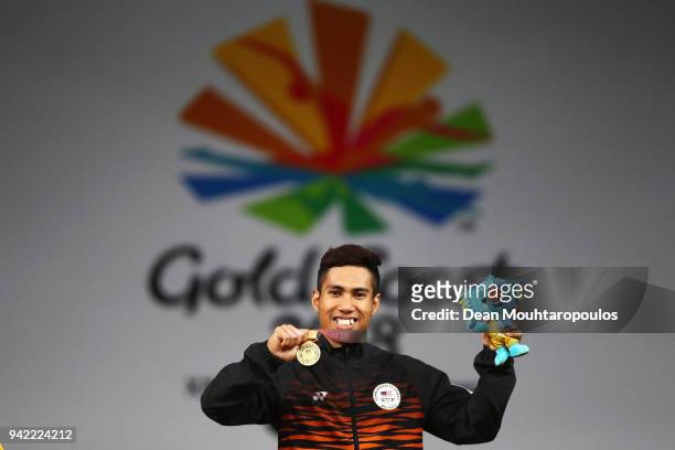 Muhamad Aznil Bidin of Malaysia celebrates on the podium after winning the gold medal after he competes in the Weightlifting Men's 62kg Final on day...