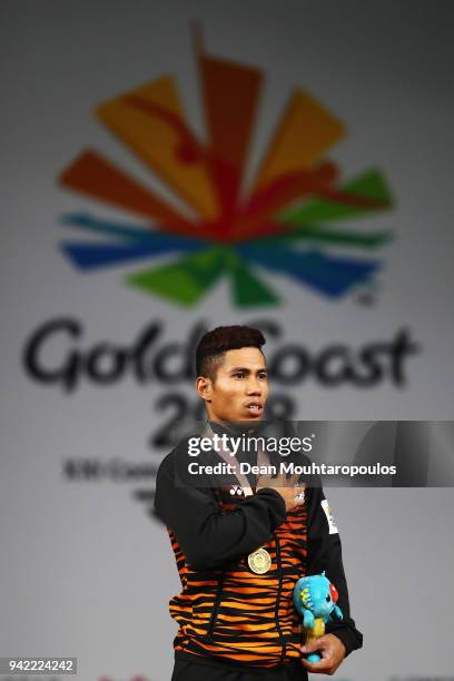 Muhamad Aznil Bidin of Malaysia celebrates on the podium after winning the gold medal after he competes in the Weightlifting Men's 62kg Final on day...