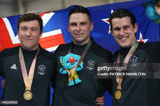 New Zealand's Ethan Mitchell, Edward Dawkins and Sam Webster celebrate their gold medal win in the men's team sprint finals track cycling event...