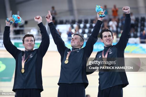 New Zealand's Ethan Mitchell, Edward Dawkins and Sam Webster celebrate their gold medal win on the podium in the men's team sprint finals track...