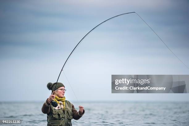 fly fisherman casting out her line - fishing line stock pictures, royalty-free photos & images