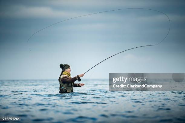 pescatore di mosca che lancia la sua linea - lenza foto e immagini stock