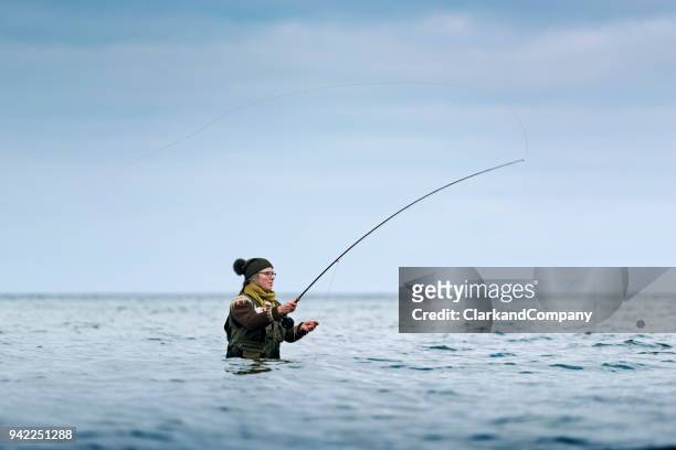 fly fisherman echando fuera de su línea de - sedal fotografías e imágenes de stock