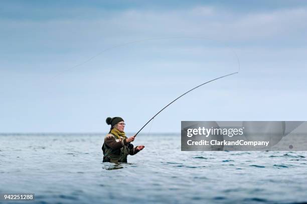 fly fisherman casting out her line - fishing line stock pictures, royalty-free photos & images