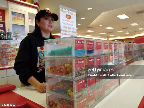 Staff member stands behind the Tasting Bar at the Jelly Belly jelly bean candy factory in Fairfield, California, and offers free samples of every...