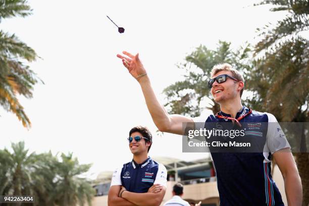 Sergey Sirotkin of Russia and Williams plays darts in the Paddock during previews ahead of the Bahrain Formula One Grand Prix at Bahrain...