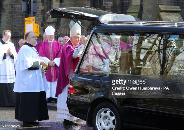 Cardinal Vincent Nichols, Archbishop of Westminster, blesses the coffin of Cardinal Keith O'Brien as it leaves the Church of St Michael in Newcastle,...