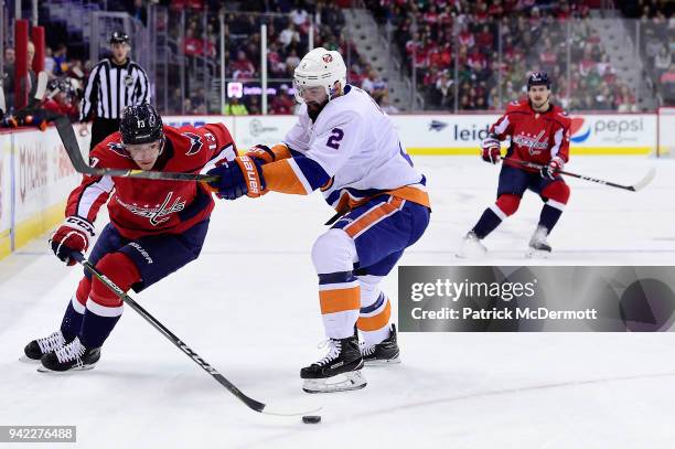 Jakub Vrana of the Washington Capitals and Nick Leddy of the New York Islanders battle for the puck in the first period at Capital One Arena on March...