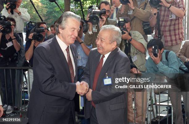 Cambodian resistance leader, Prince Norodom Sihanouk, shakes hands with French Foreign Minister Roland Dumas, after attending the International...
