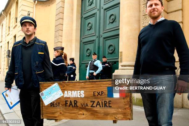 Two members of the "Survie" association carry a symbolique crate of weapons in front of the French Ministry of the Army to commemorate the...