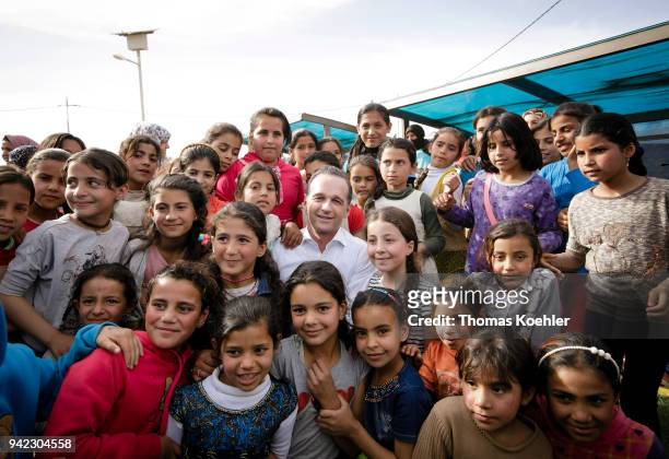 German Foreign Minister Heiko Maas posing for a picture with children during his visit of the Al-Azraq refugee camp on April 05, 2018 in Al-Azraq,...
