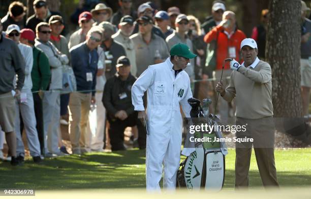 Jose Maria Olazabal of Spain pulls a club from his bag alongside caddie Michael J. Batty during the first round of the 2018 Masters Tournament at...