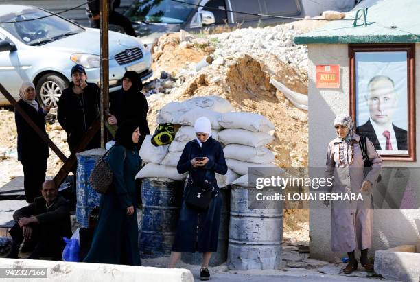 Relatives of Syrians they believe were kidnapped by Jaish al-Islam fighters wait on the Syrian government-held side of the Wafideen checkpoint on the...