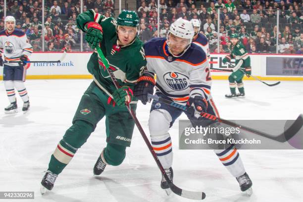 Andrej Sekera of the Edmonton Oilers and Nino Niederreiter of the Minnesota Wild skate to the puck during the game at the Xcel Energy Center on April...