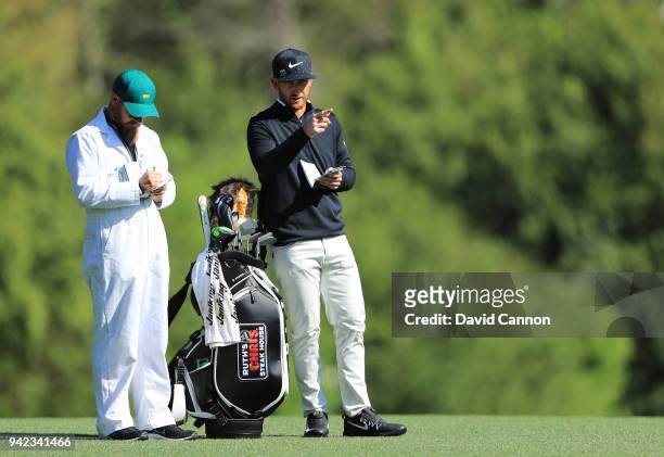 Kevin Chappell of the United States waits with his caddie Joe Greiner on the fifth hole during the first round of the 2018 Masters Tournament at...