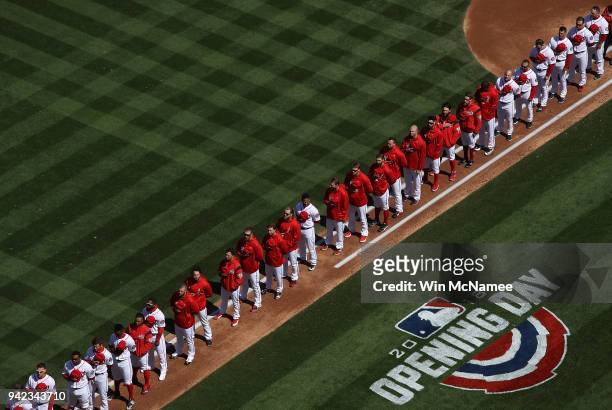 Members of the Washington Nationals line the baseline as they listen to the playing of the national anthem during the the home opener against the New...