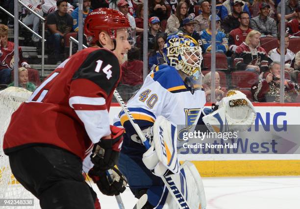 Carter Hutton of the St Louis Blues gets ready to make a save as Richard Panik of the Arizona Coyotes looks for the puck at Gila River Arena on March...