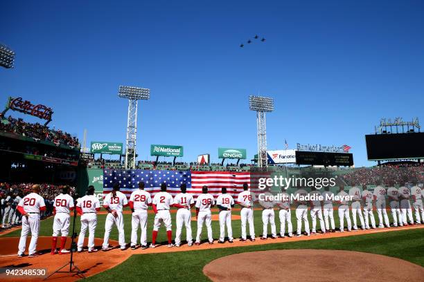 Members of the Boston Red Sox watch a flyover from the 134th Fighter Squadron from Burlington, Vermont before their home opening game against the...