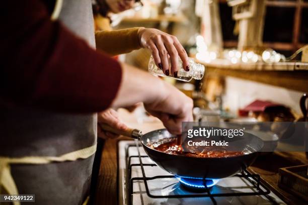 young couple cooking in kitchen - sauce stock pictures, royalty-free photos & images