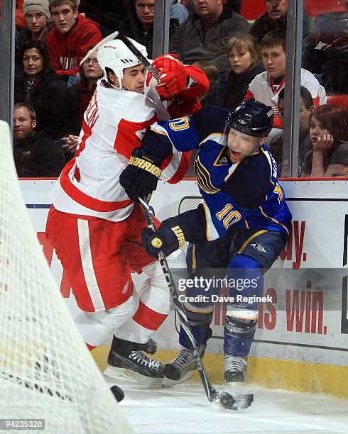 Andy McDonald of the St. Louis Blues skates with the the puck around the defense of Jonathan Ericsson of the Detroit Red Wings during a NHL game at...